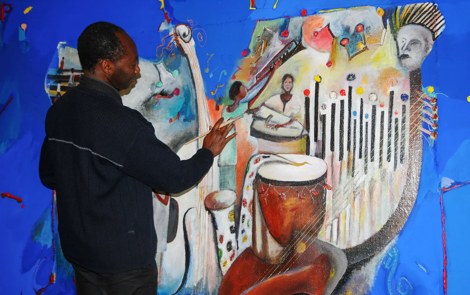 Braïma Injaï peignant une œuvre dans son atelier
